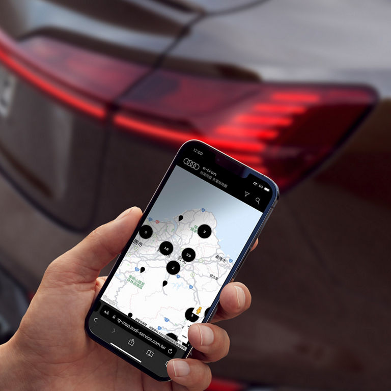 Man with smartphone in front of Audi Q8 Sportback e-tron