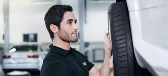 An Audi mechanic inspecting the tyre and rim of an Audi vehicle