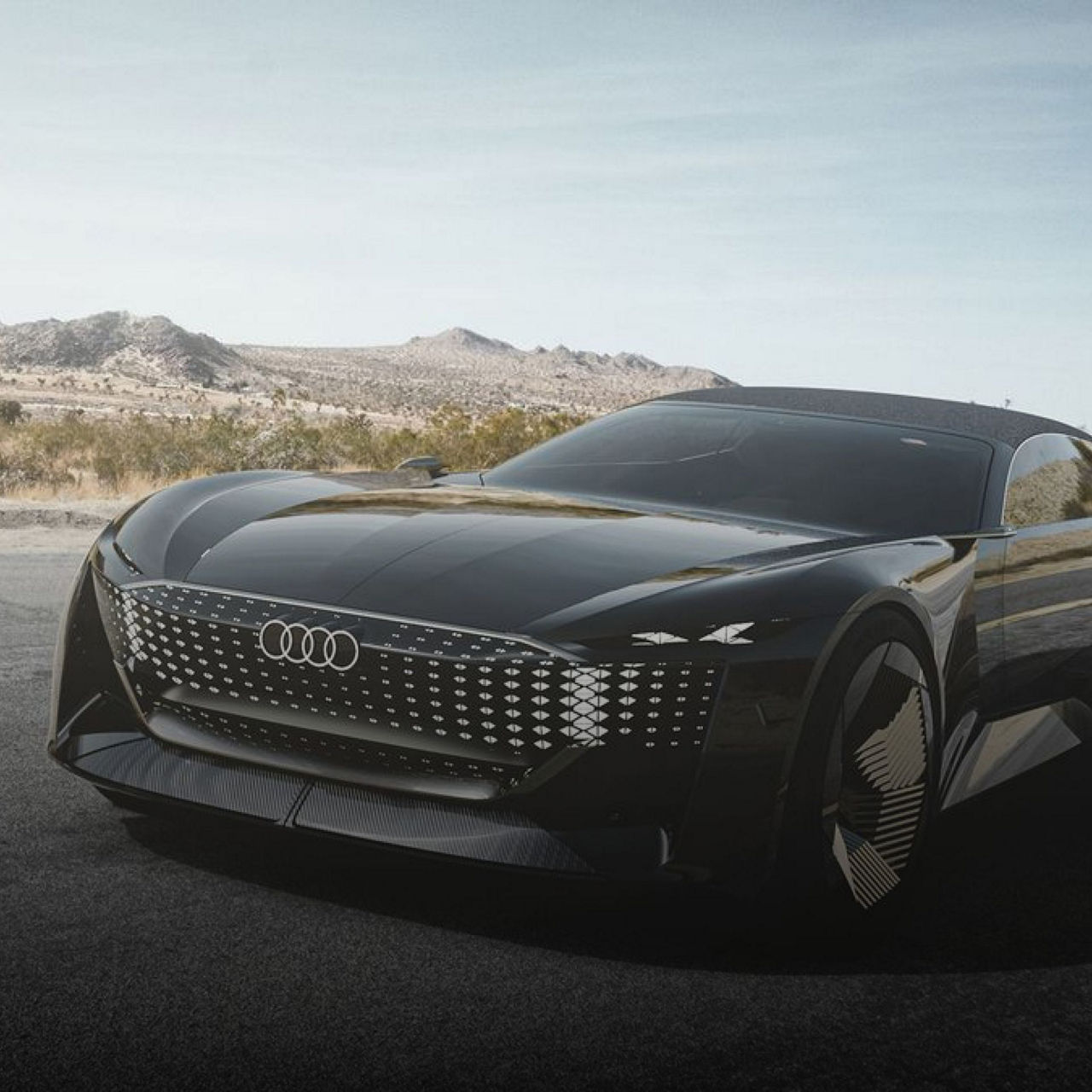 Futuristic black Audi concept vehicle with illuminated grille, roadside in desert