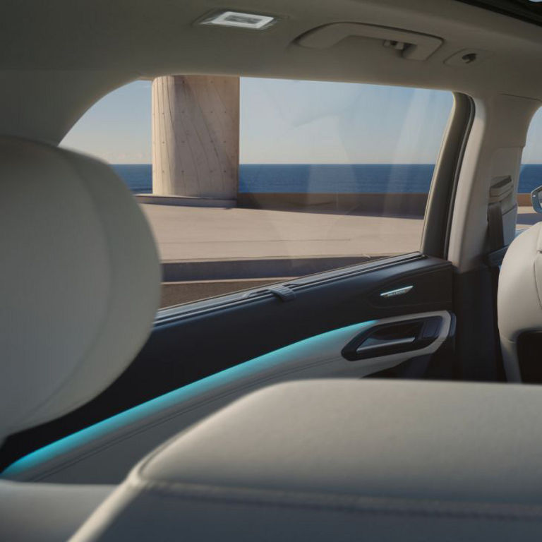 Interior view of an Audi vehicle with a focus on the passenger side, showcasing the ocean view through the window