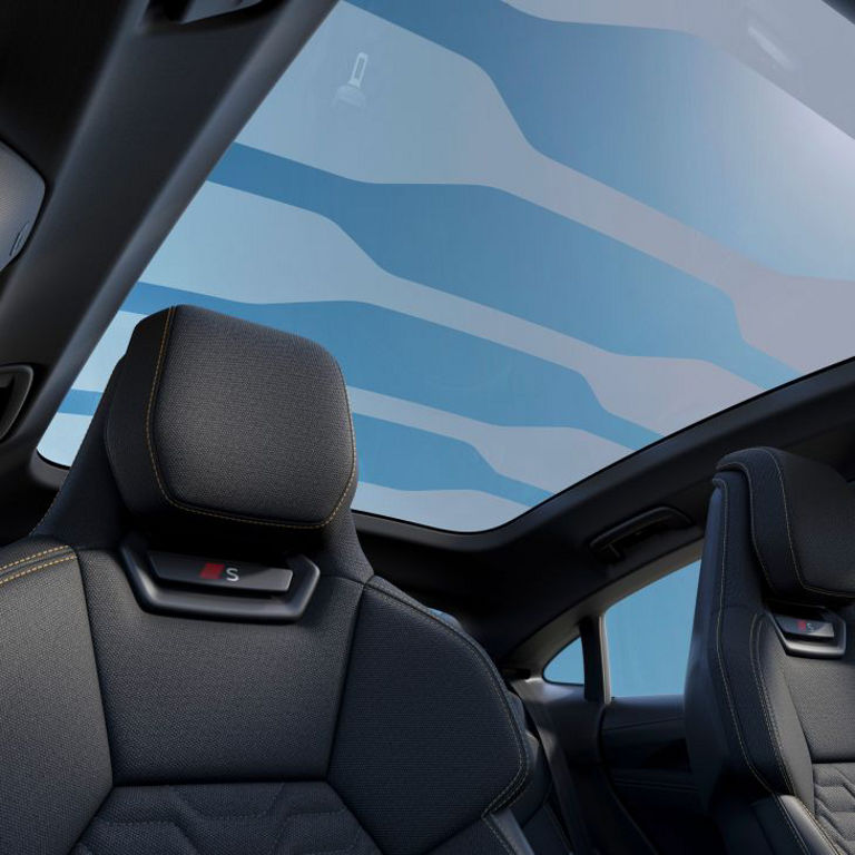 Interior view of an Audi vehicle with panoramic sunroof and black seats