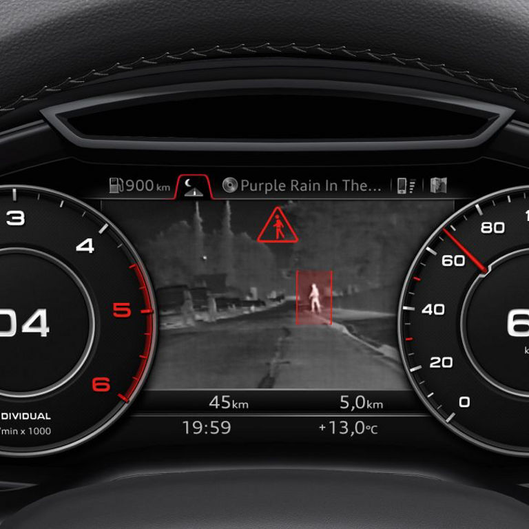 The dashboard in an Audi vehicle showing speedometer, a gear indicator, and a pedestrian warning on the central display