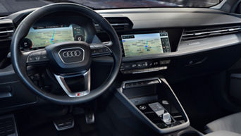 Interior of the front of an Audi electric vehicle, showing the steering wheel and digital displays