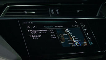 The digital display inside an Audi electric vehicle displaying a driving route on a map of the UK