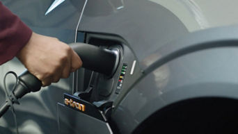 Hand placing charger in to the charge port of an Audi e-tron electric vehicle