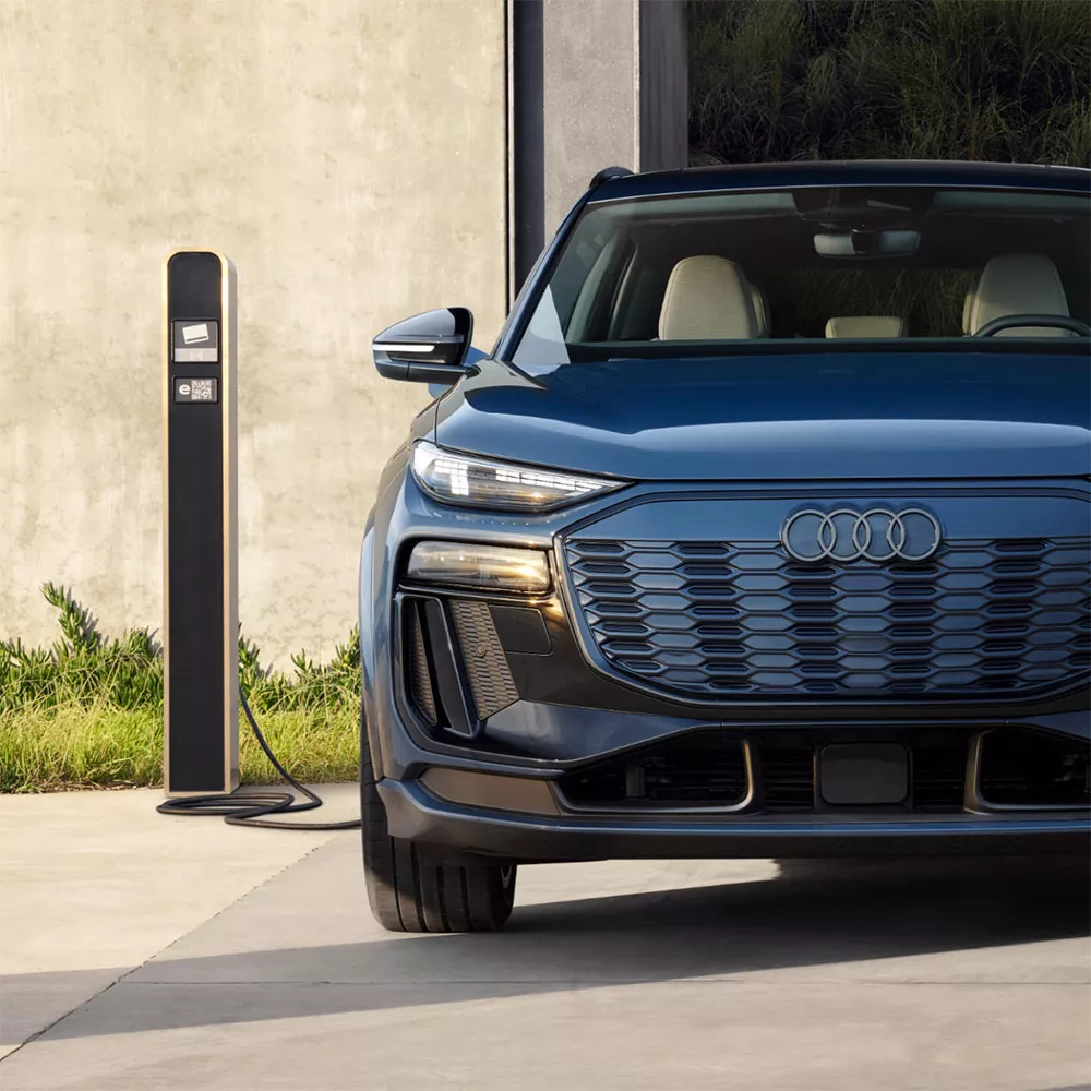 A parked Audi Q6 e-tron electric vehicle on charge, front of the vehicle facing us