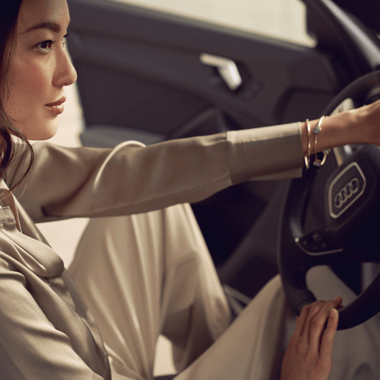 Young woman at the wheel of an Audi vehicle