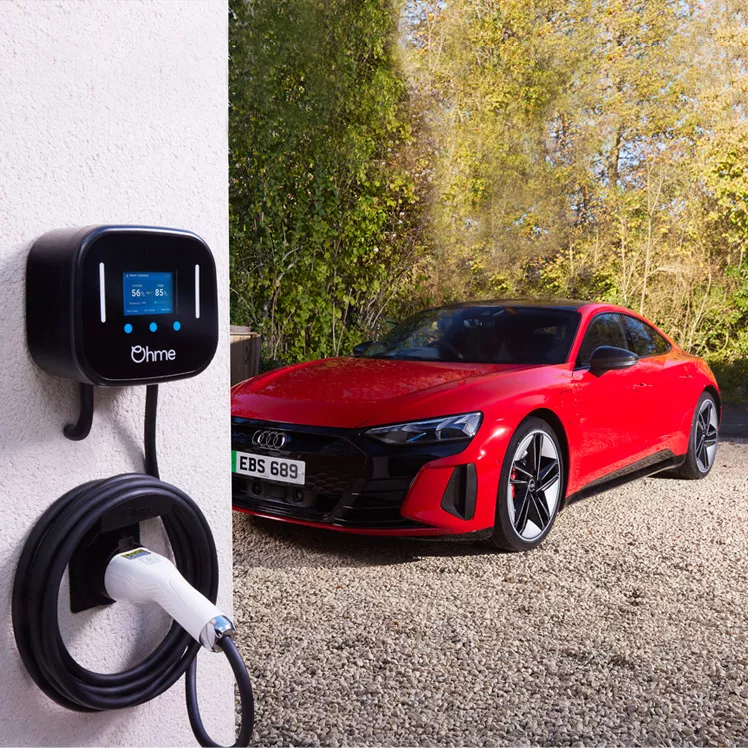 Wall-mounted electric vehicle charger next to a red Audi e-tron coupe