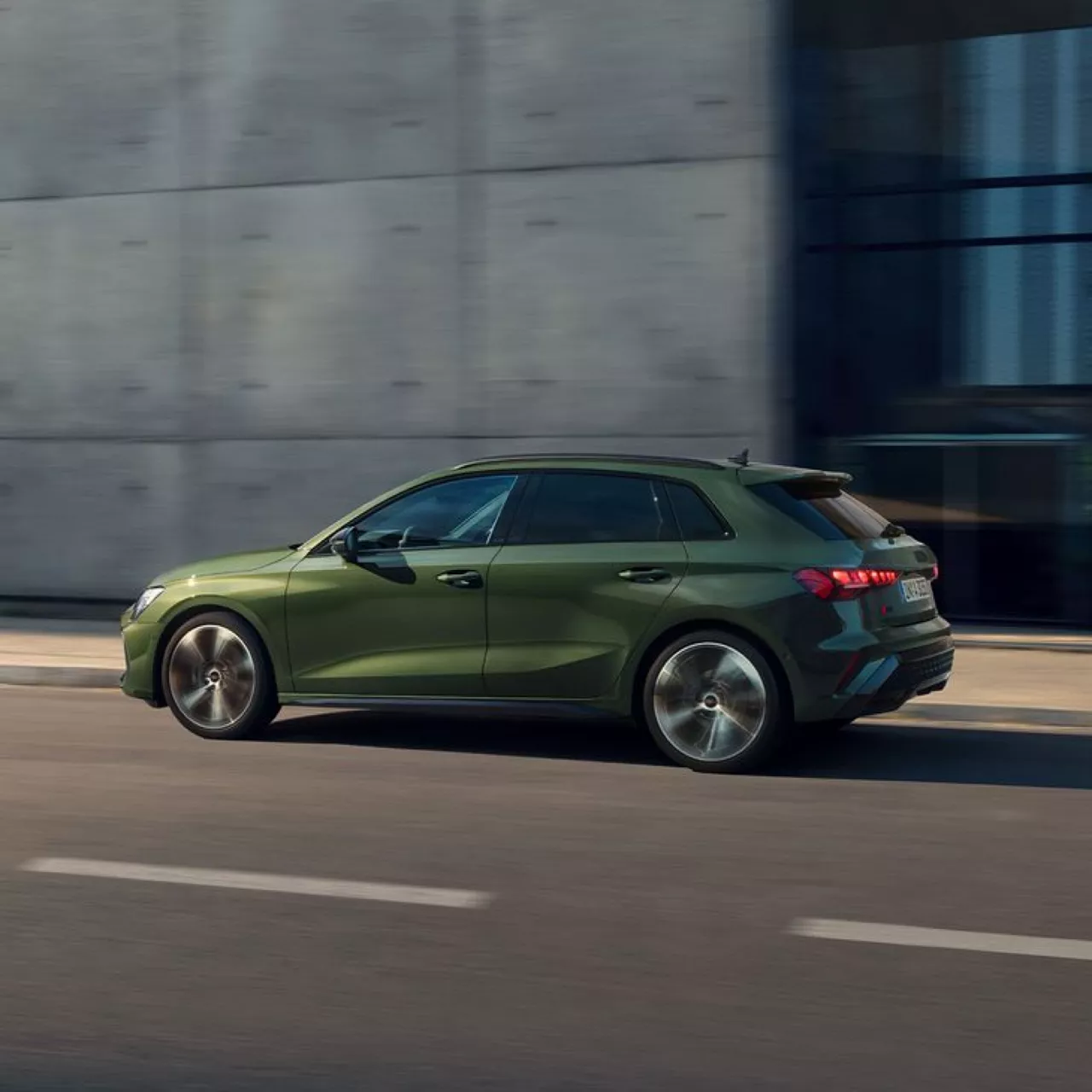 A dark green Audi A3 Sportback in movement, on a city road