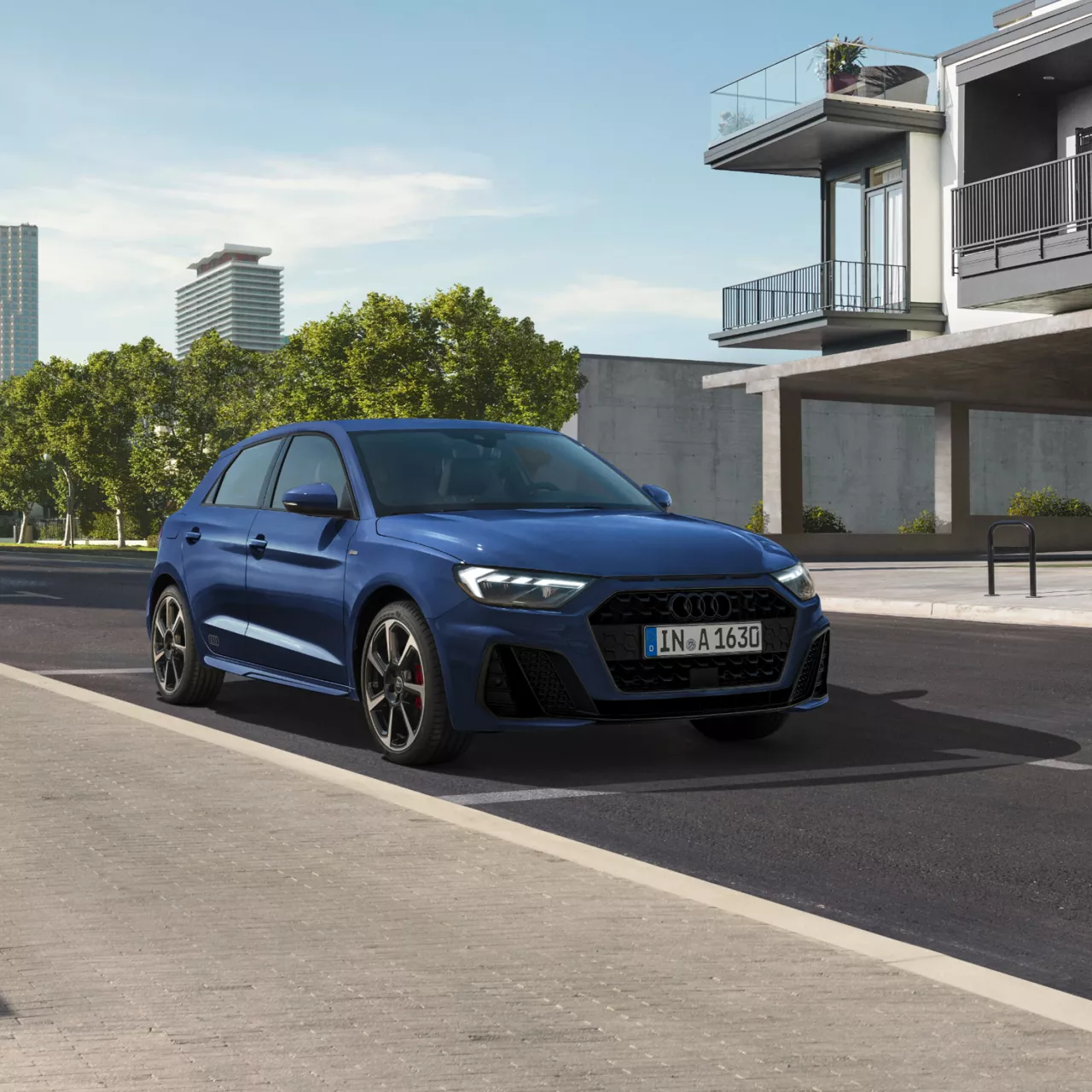 Dark blue Audi A1 Sportback parked on a residential street, surrounded by trees and next to a house