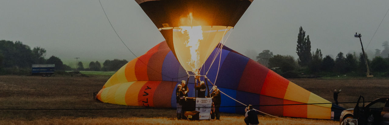 Hot air balloon being inflated with fire on misty field