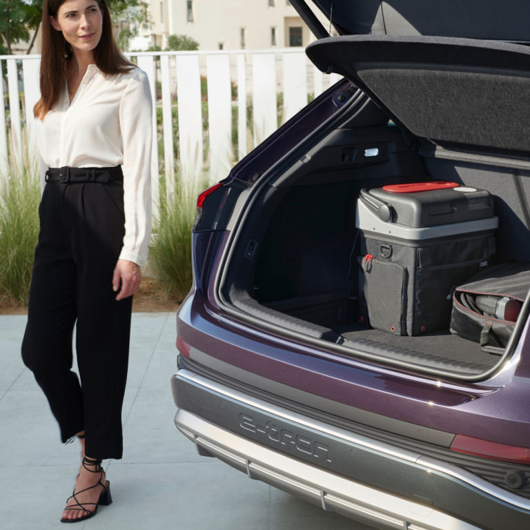 The rear of a parked Audi e-tron vehicle with the boot door open showing various items of storage