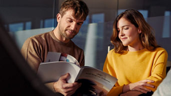 A young couple looking through an Audi brochure