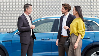 An Audi specialist with a young couple all stood in beside an Audi vehicle