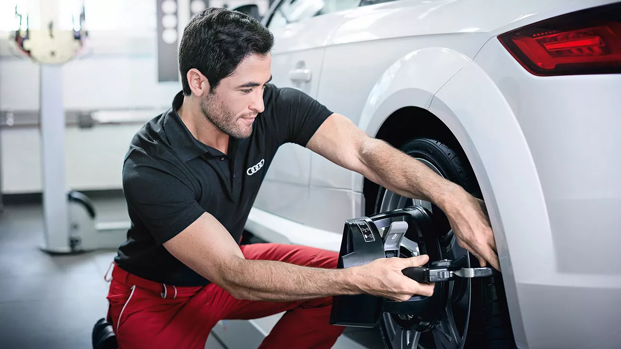 An Audi mechanic inspecting the wheel of an Audi vehicle