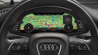 The driver steering wheel and digital dashboard showing a map and other information in an Audi vehicle