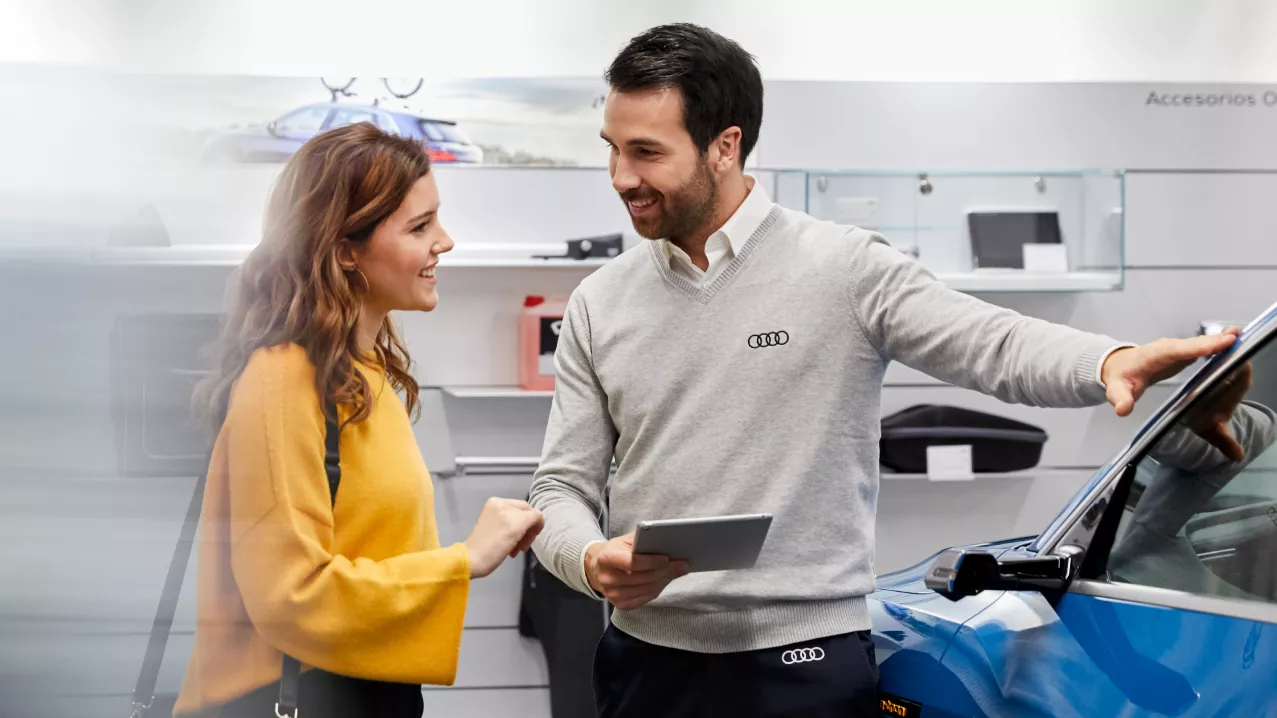 An Audie specialist with a customer beside an Audi vehicle