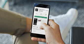 A hand holding a phone with the the Audi Connect plug & play app loaded on the Google Play store