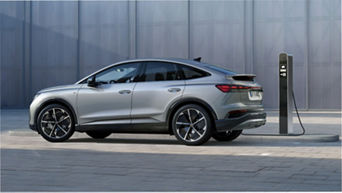 Silver electric SUV charging at a public charging station.