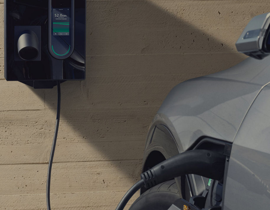 A parked Audi vehicle plugged in and on charge in an urban setting