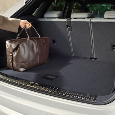 Arm placing a bag in the boot of an Audi Q3.