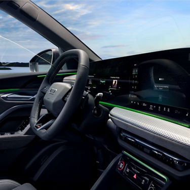 Interior of a car with a digital dashboard and ambient lighting.
