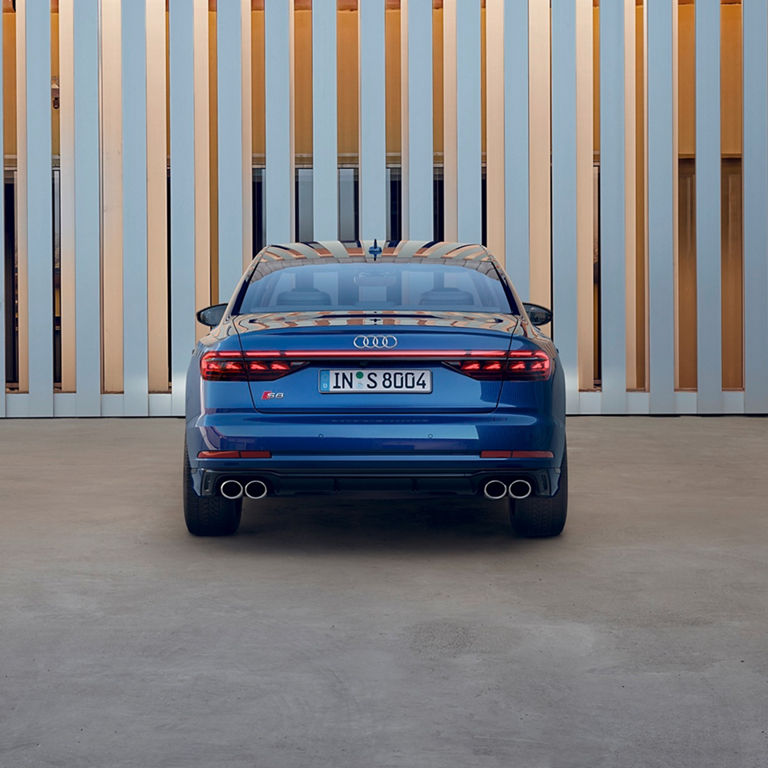 Rear view of blue Audi A8 S8 near building