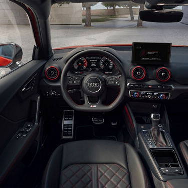 Interior of an Audi car with a view of dashboard, steering wheel, and infotainment system.