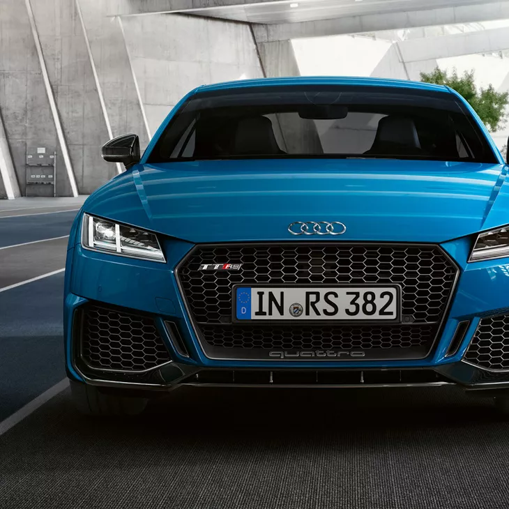 Front view of blue Audi TT RS Coupe in a concreate building.