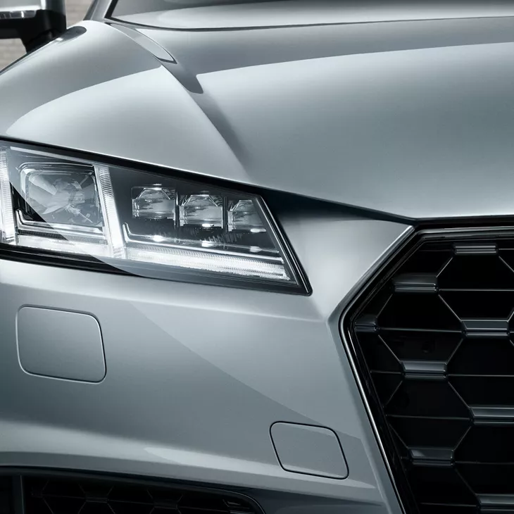 Front close up half bonnet view of a silver Audi TT Coupé.