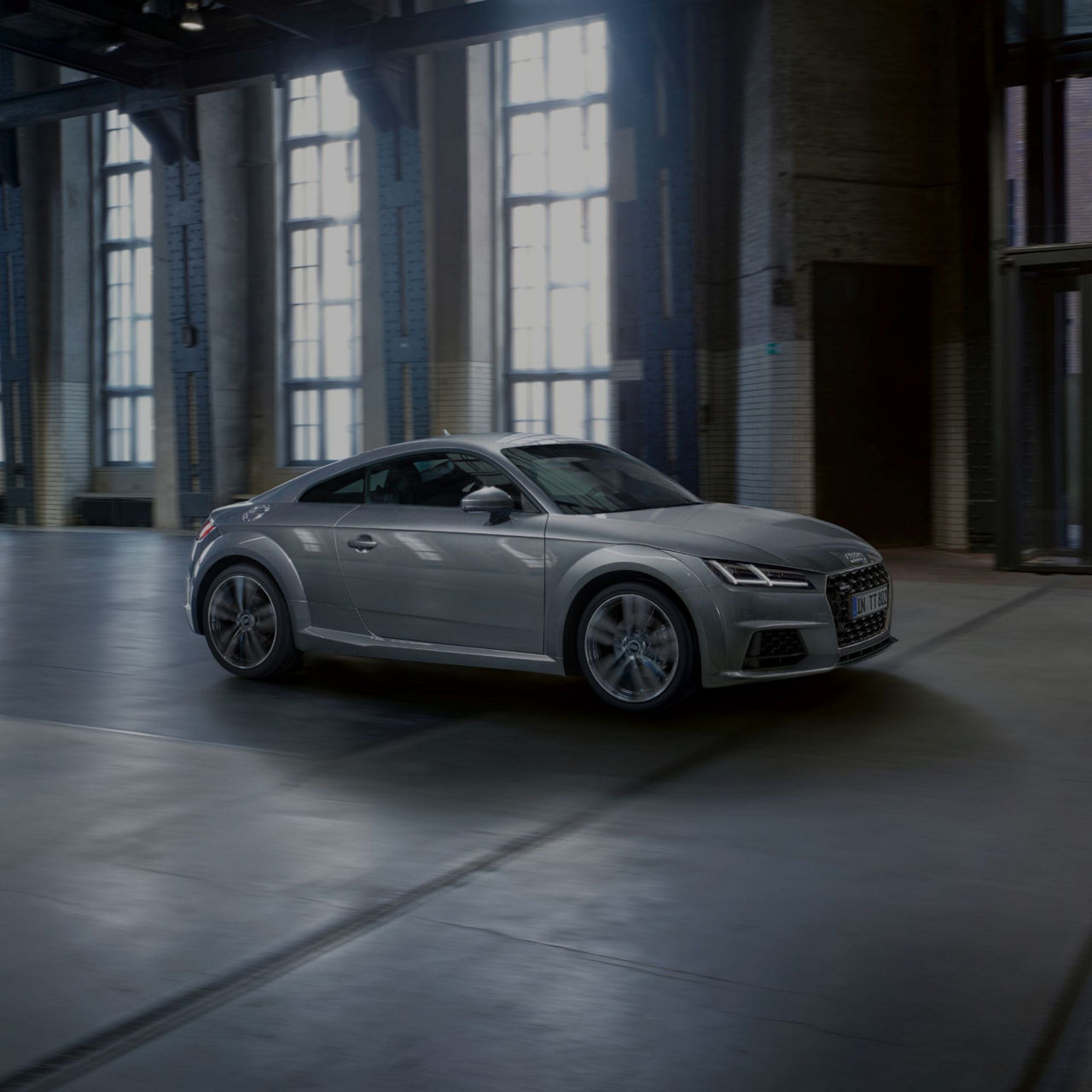 Parked white Audi TT Coupé in an empty building.