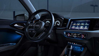 An Audi A1 Sportback car interior with steering wheel, dashboard displays, and center console.