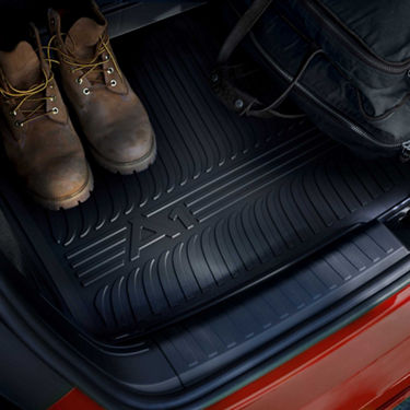 A pair of boots on a car's rubber floor mat of Audi A1 Sportback, showing durability and adventure.