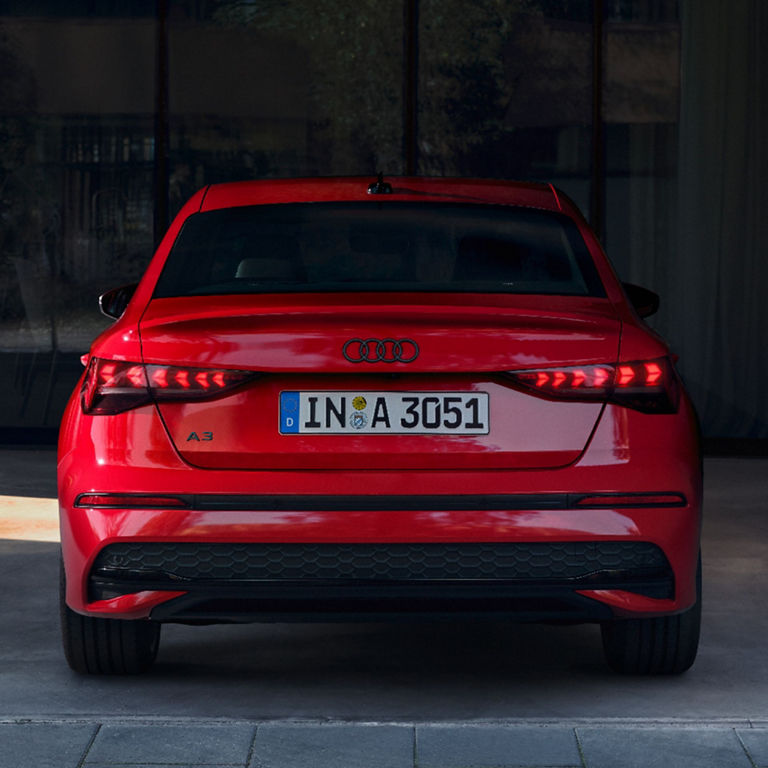 Rear view of a red Audi A3 vehicle with license plate.