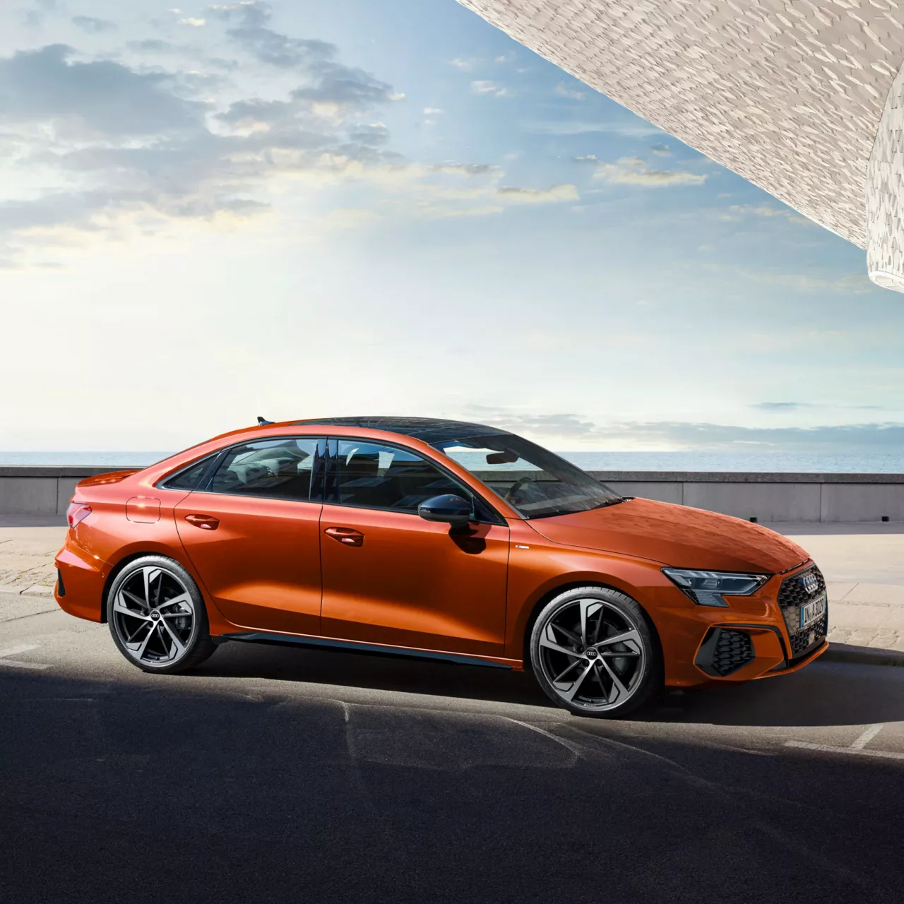 Orange Audi sedan parked outdoors with clear skies in the background.