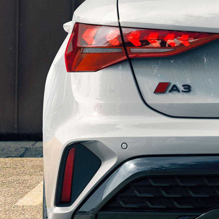 Close-up of an Audi A3's rear with distinctive tail lights and European license plate.