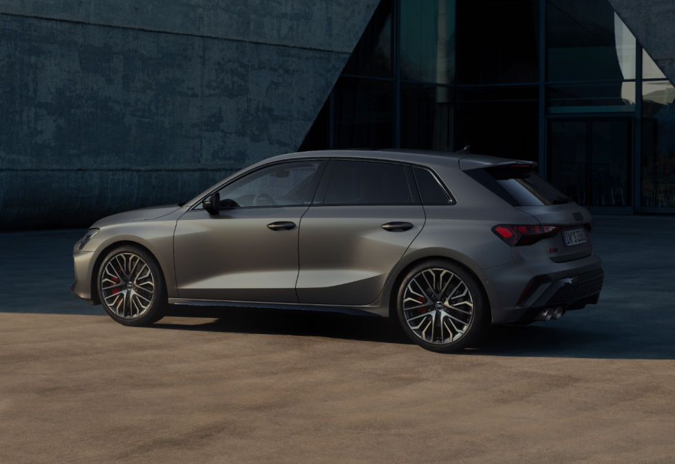 Gray car parked outside a modern building, emphasizing sleek design.