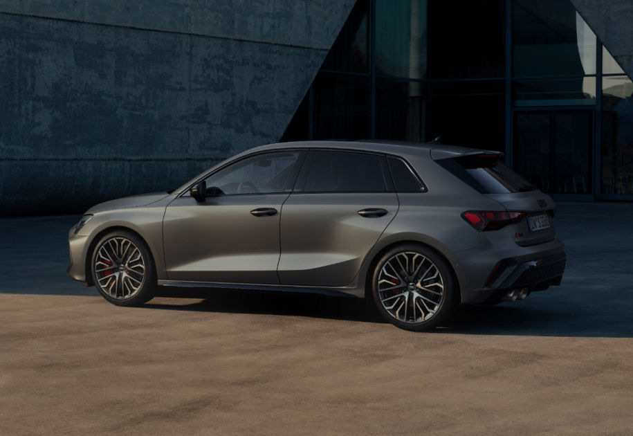 Gray car parked outside a modern building, emphasizing sleek design.