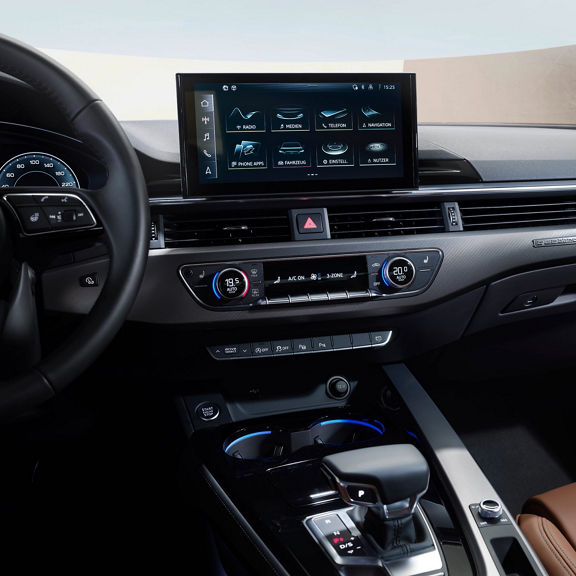 Car dashboard with touchscreen display, steering wheel, and climate controls.