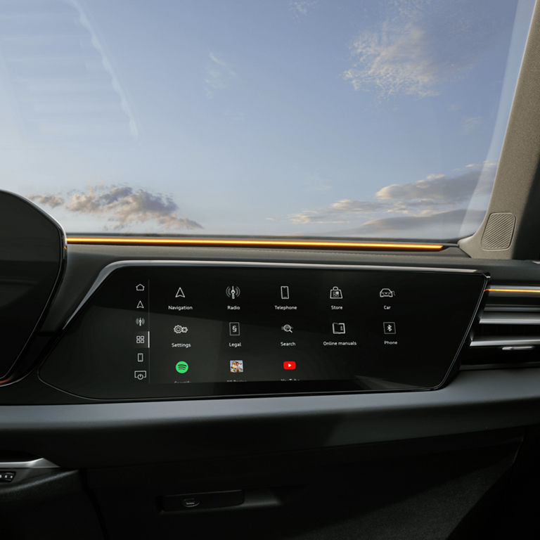 Car dashboard with a touchscreen displaying navigation and media icons, with a view outside.