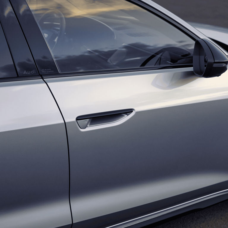 Close-up of a silver Audi A5 Avant's door and side mirror.