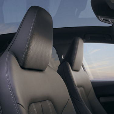 Close-up of a car's leather seats with headrest in focus, interior detail.