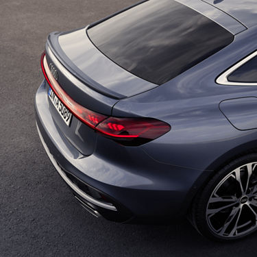 Rear view of a dark blue Audi with LED taillights and alloy wheels.
