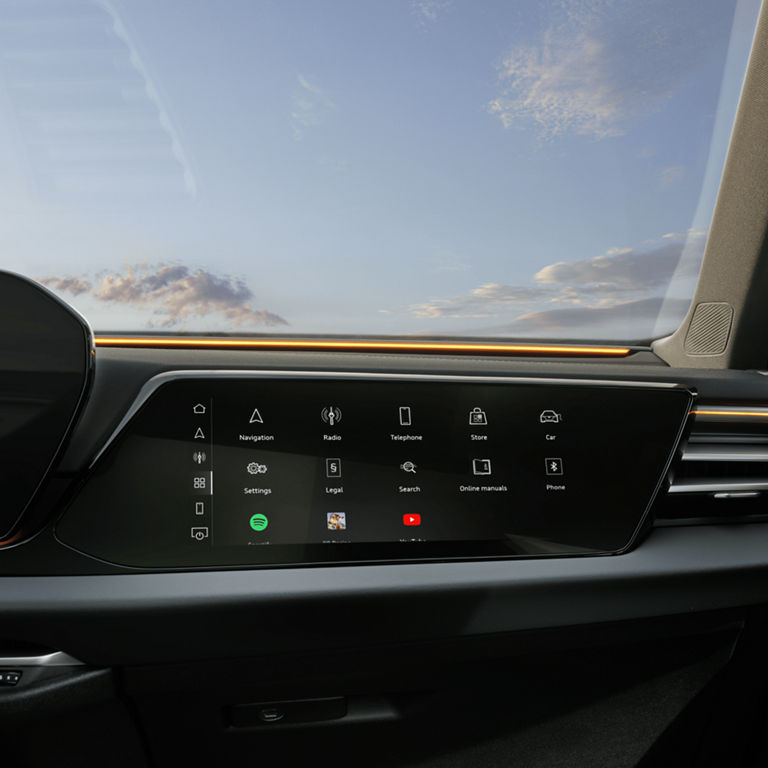 Car dashboard with touchscreen interface showing apps like navigation and radio.