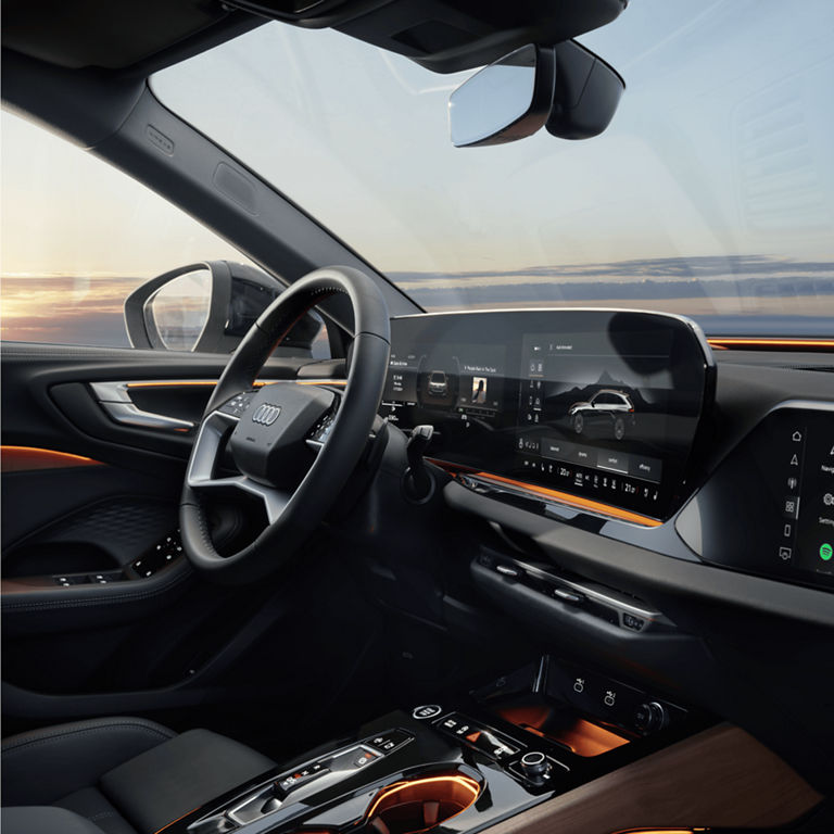 Car's interior at sunset with digital dashboard and infotainment system.