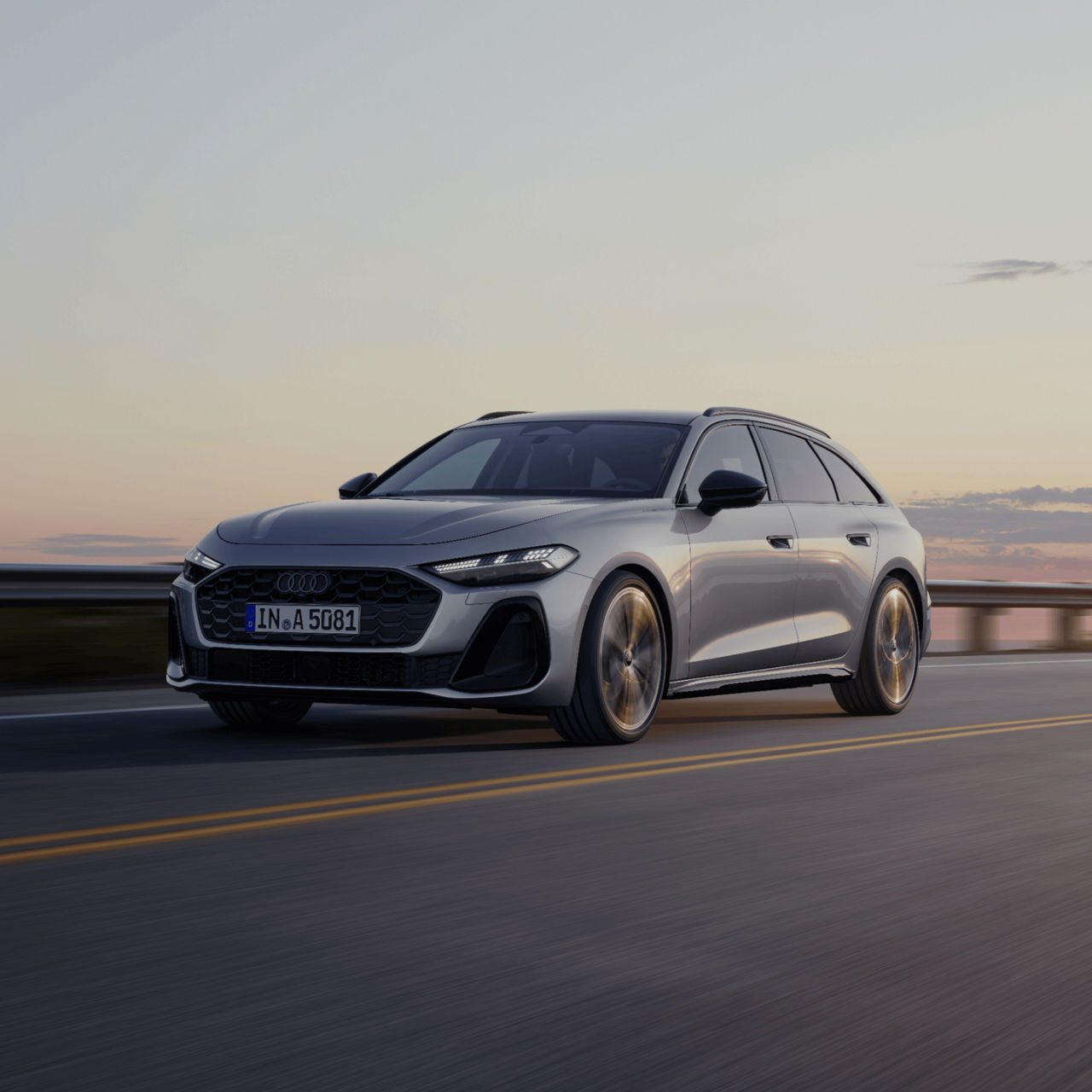 Silver Audi car in motion on a highway at dusk.