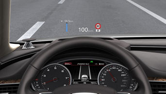 Car dashboard with digital speedometer and head-up display showing speed and navigation.