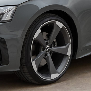Close-up of an Audi car's alloy wheel, showcasing the tire and part of the fender.