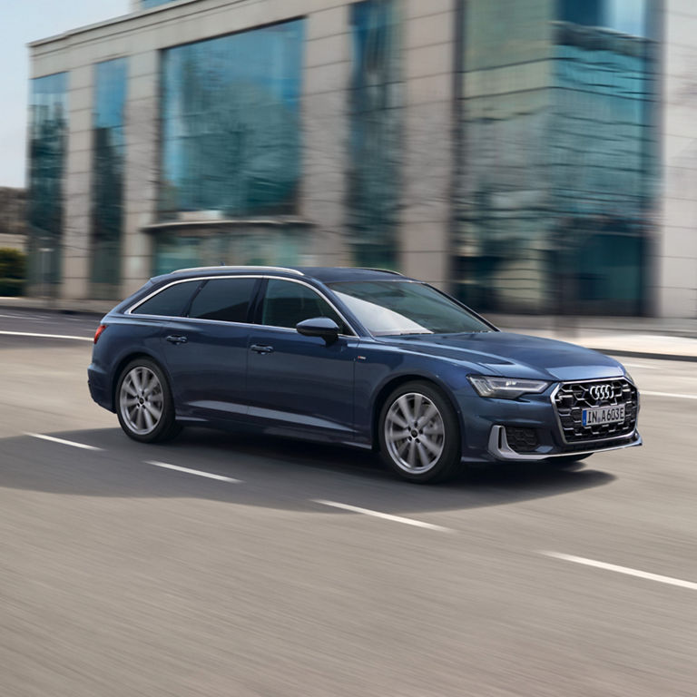 A blue Audi car driving on a city street.