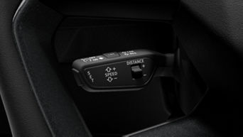 Cruise control buttons on a car's steering wheel with labels for speed and distance settings.